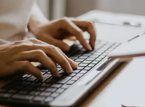 Close-up of healthcare billing specialist entering data into an EHR system to prevent claim errors